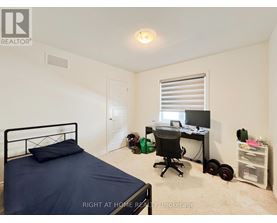 A bedroom with a bed, desk, and chair.