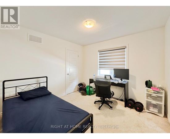 A bedroom with a bed, desk, and chair.