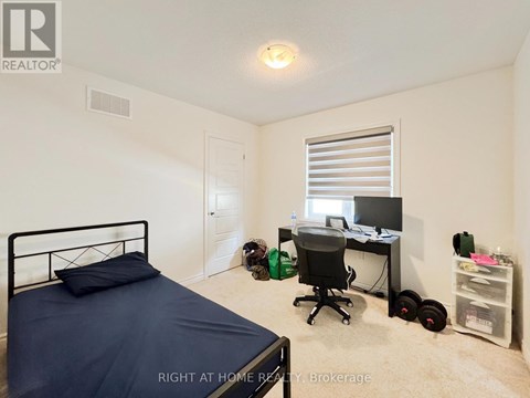 A bedroom with a bed, desk, and chair.