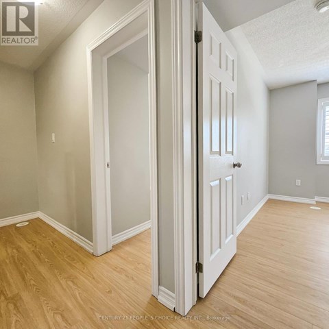 A room with a white door and wooden flooring.
