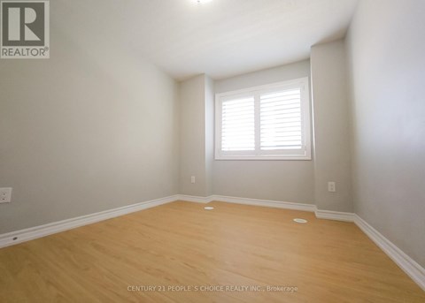 A room with a window and wooden flooring.