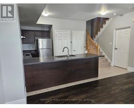 A kitchen with a wooden counter and a refrigerator.