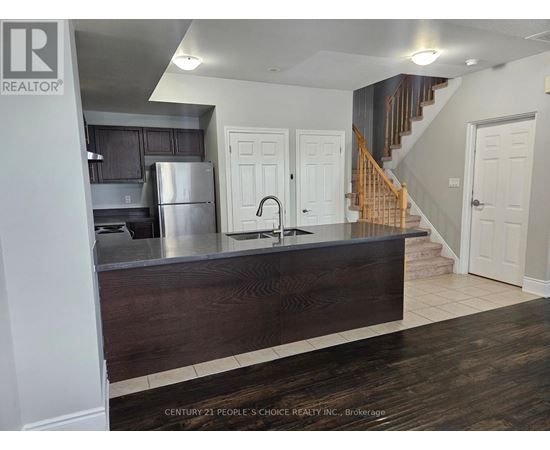 A kitchen with a wooden counter and a refrigerator.