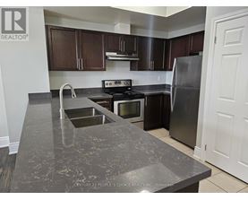 A kitchen with a granite countertop and stainless steel appliances.