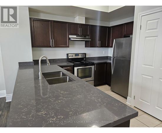 A kitchen with a granite countertop and stainless steel appliances.
