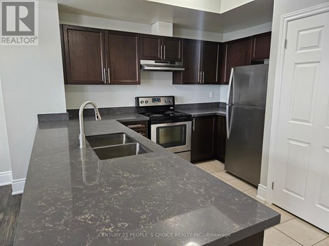 A kitchen with a granite countertop and stainless steel appliances.