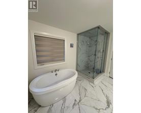 A white bathtub with a glass shower door in a bathroom.