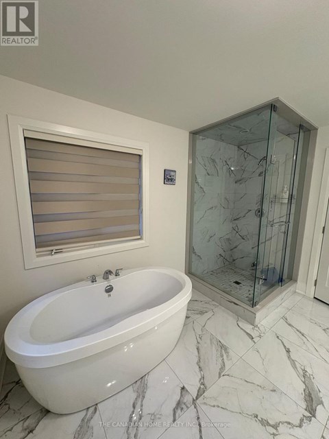 A white bathtub with a glass shower door in a bathroom.