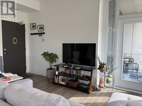 A living room with a grey couch and a black television.