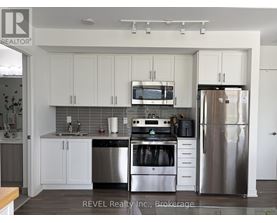 A kitchen with white cabinets and stainless steel appliances.