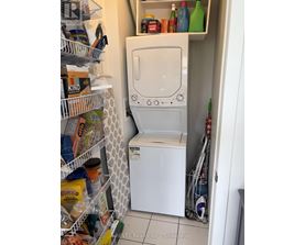 A white washing machine is in a small laundry room.
