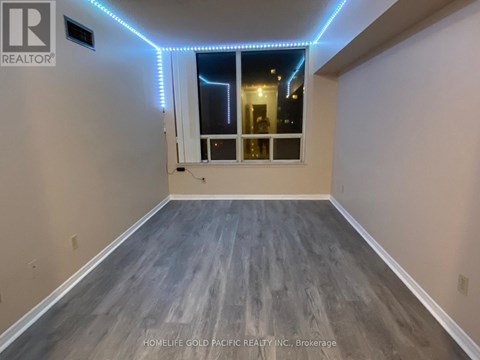A room with a window and a wooden floor.
