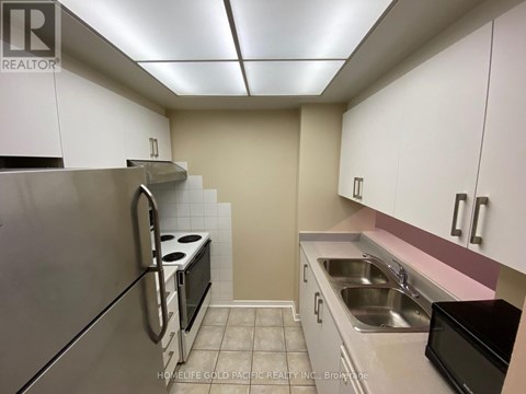 A kitchen with white cabinets and a stainless steel refrigerator.