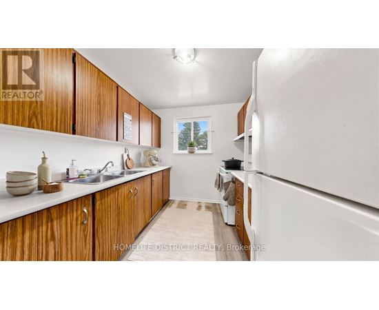 A kitchen with wooden cabinets and a white refrigerator.