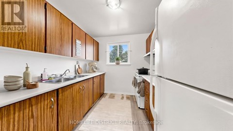 A kitchen with wooden cabinets and a white refrigerator.