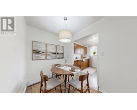 A dining room with a table set for two and a painting on the wall.