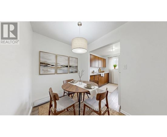 A dining room with a table set for two and a painting on the wall.