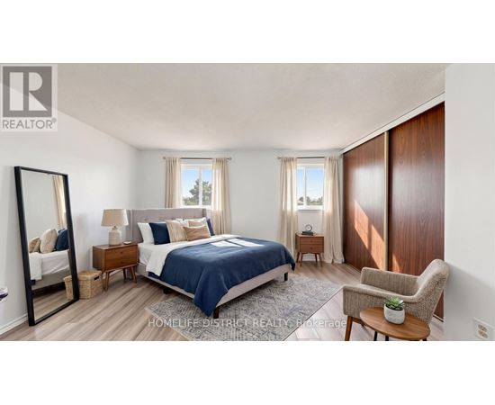 A bedroom with a bed, chair, and mirror.