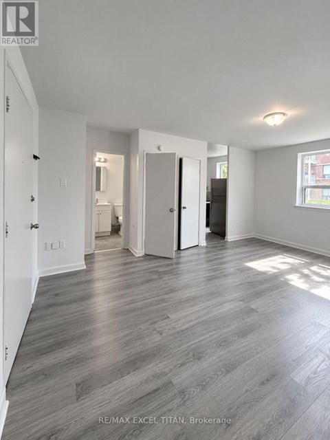 A spacious room with RE/MAX EXCEL TITAN brokerage logo on the wall.