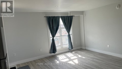 A room with a window and curtains, and a logo that says REALTOR.