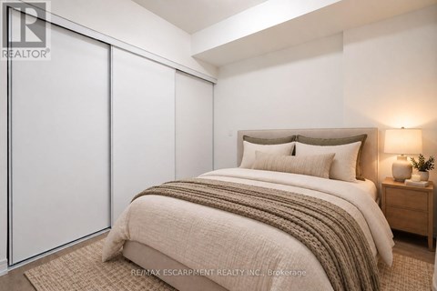 A bedroom with a bed, nightstand, and sliding door.