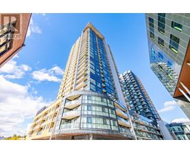 A tall building with many windows and balconies is seen from a low angle.