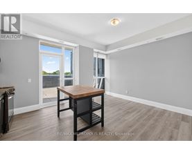 A dining room with a wooden table and chairs, and a sliding glass door leading to a balcony.
