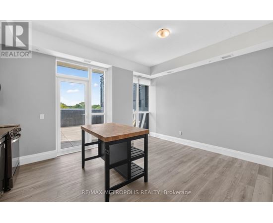 A dining room with a wooden table and chairs, and a sliding glass door leading to a balcony.