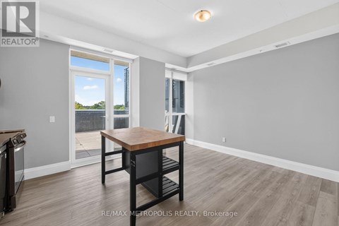 A dining room with a wooden table and chairs, and a sliding glass door leading to a balcony.