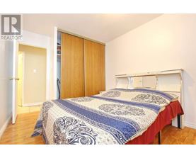 A bedroom with a bed, a wardrobe and a doorway leading to another room.