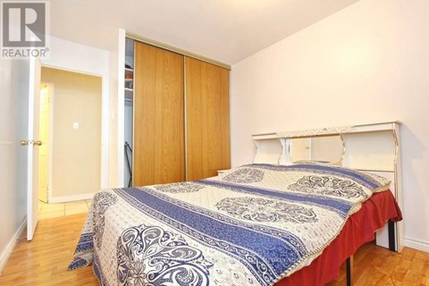 A bedroom with a bed, a wardrobe and a doorway leading to another room.