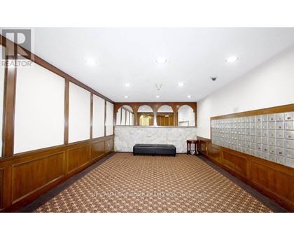 A spacious room with a checkered floor and wooden paneling on the walls.
