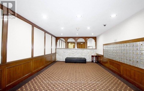 A spacious room with a checkered floor and wooden paneling on the walls.