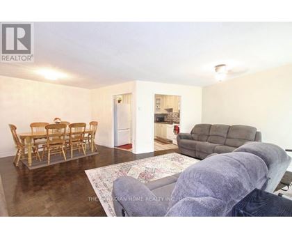 A living room with a dining table and chairs.
