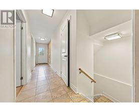 A hallway with white walls and a tiled floor.