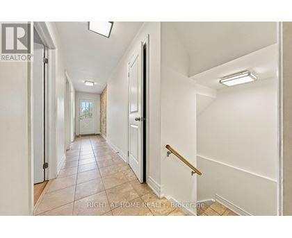 A hallway with white walls and a tiled floor.