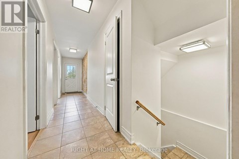 A hallway with white walls and a tiled floor.