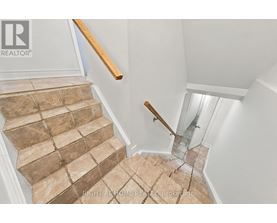 A staircase with a glass railing and wooden handrail.