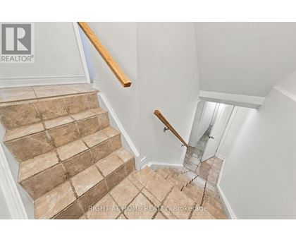 A staircase with a glass railing and wooden handrail.