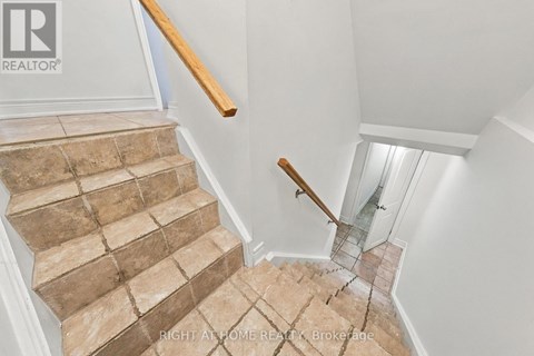 A staircase with a glass railing and wooden handrail.
