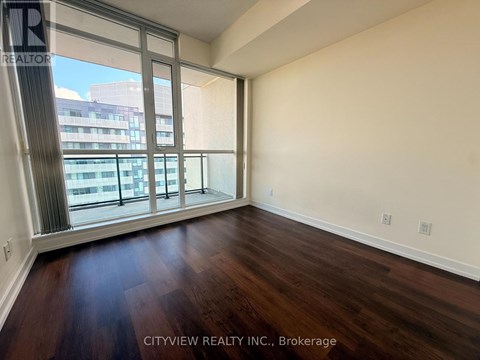 A room with a large window and wooden flooring.