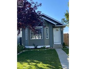 A small house with a white door and a small front yard.