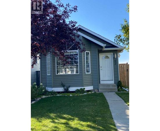 A small house with a white door and a small front yard.
