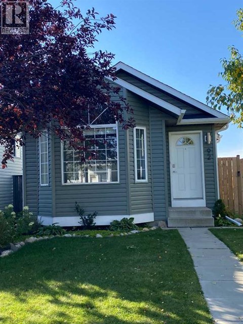 A small house with a white door and a small front yard.