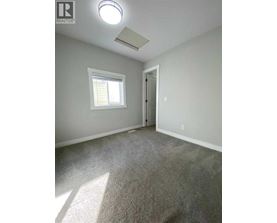 A room with a carpeted floor and a window.