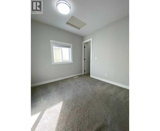 A room with a carpeted floor and a window.