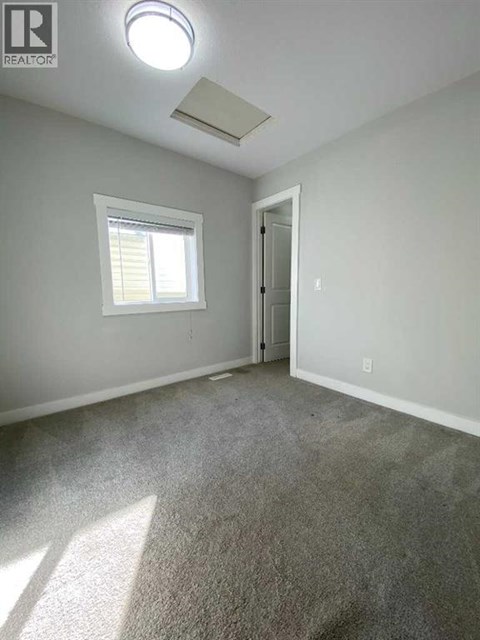 A room with a carpeted floor and a window.