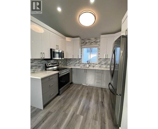 A modern kitchen with a refrigerator on the right side.