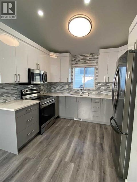 A modern kitchen with a refrigerator on the right side.