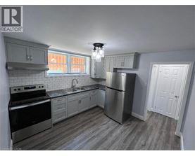 A kitchen with a stove, sink, and refrigerator.